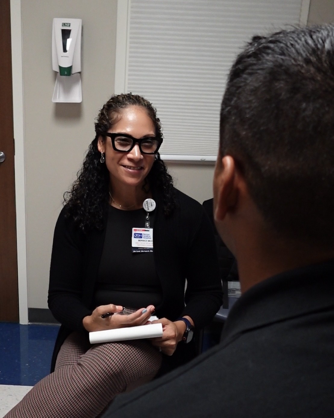 Dr. Bernice McCoy speaking with a patient in a clinical setting.