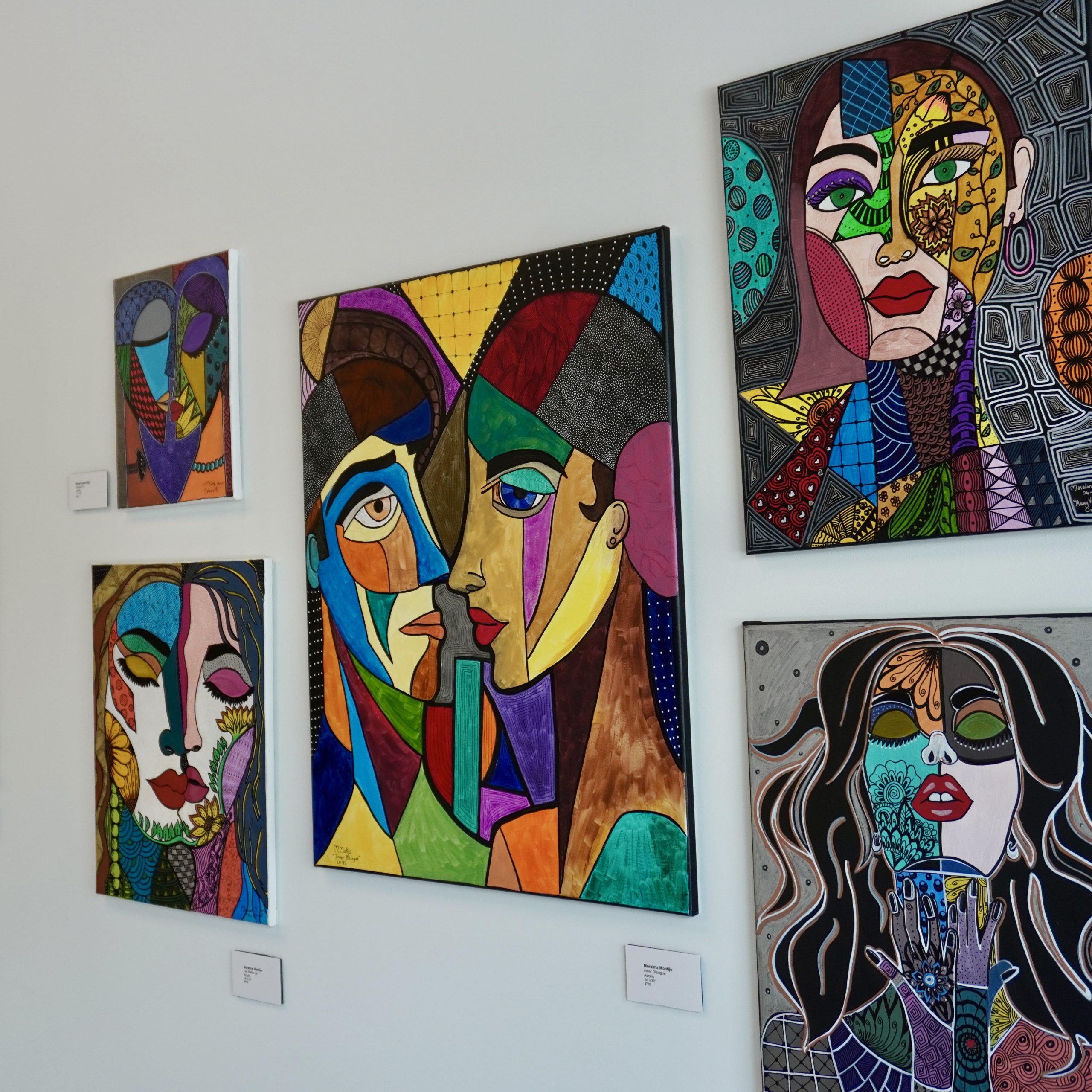 Colorful portrait artwork displayed inside a gallery.